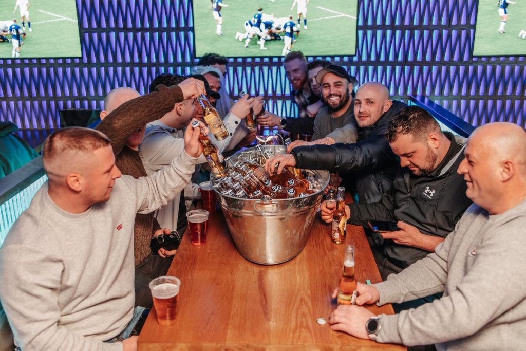group of men sharing a beer bucket